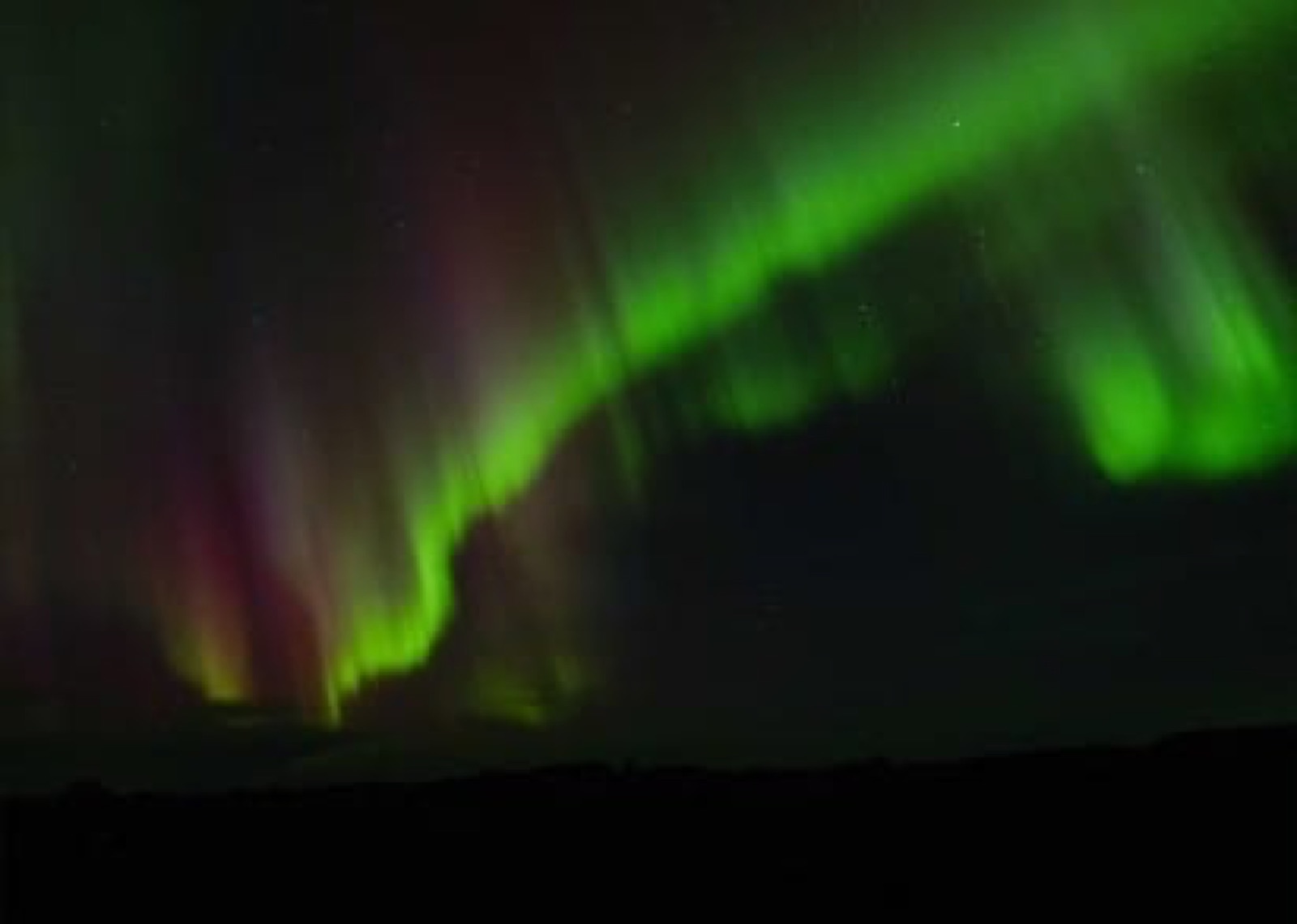Green magenta aurora borealis dancing Finnish sky