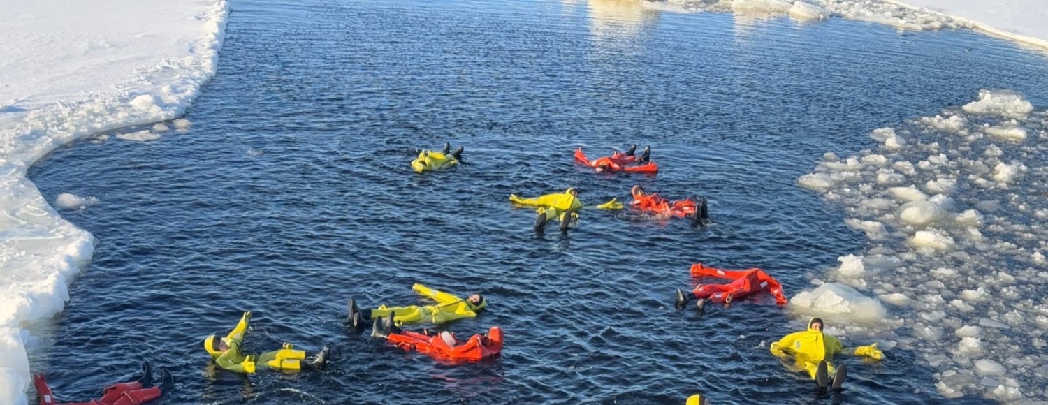 Group ice floating in survival suits, frozen Gulf of Bothnia