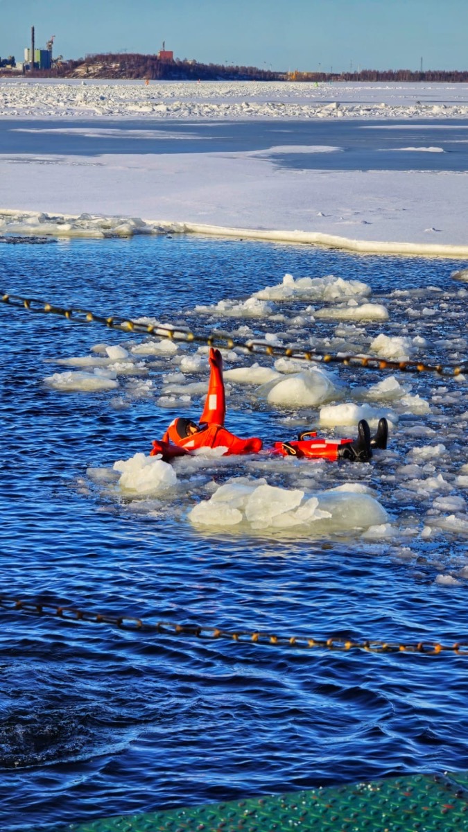 Floating in a survival suit among ice floes on the frozen sea
